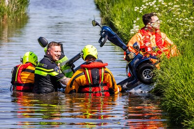 Scootmobieler rijdt sloot in in Strijen, politie en brandweer tillen man eruit