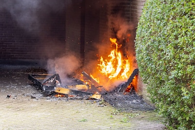 Bank onder afdak vliegt in brand in Oss, supermarktmedewerkers schieten te hulp met tuinsproeier