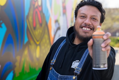 Graffiti vandalisme? Junior tovert saaie muren om in kleurige kunstwerken én verdient er geld mee