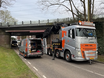 Vrachtwagen botst met te hoge heftruck tegen brug, treinverkeer ligt tijd stil