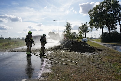 Opraapwagen met gemaaid gras in brand in Dalfsen, chauffeur lost lading op de weg