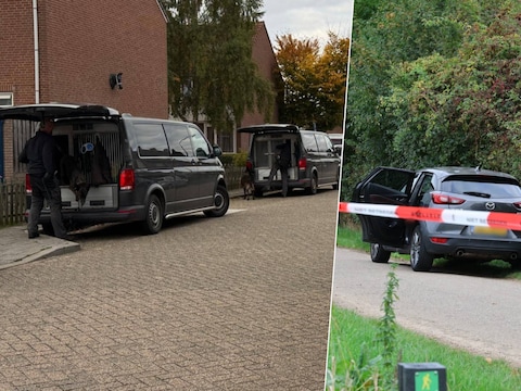 Drie politiebusjes in de Jeroen Boschstraat in Boxmeer. Rechts de Mazda waar de dode man in werd gevonden.