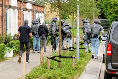 ‘Is de deur open’, vraagt politie aan de telefoon: vlak daarna vallen zwaarbewapende agenten flat bi