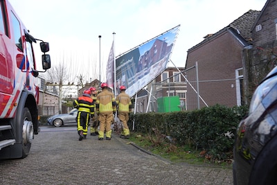 Brandweer verwijdert scheefhangend frame met spandoek in Dongen