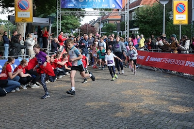 Eerste kinderen ‘vliegen’ over het parcours tijdens de Kidsrun van de Eindhovense marathon