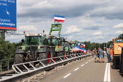 Boeren met omgekeerde vlaggen blokkeren met hun voertuigen kruispunt bij Frans op den Bult