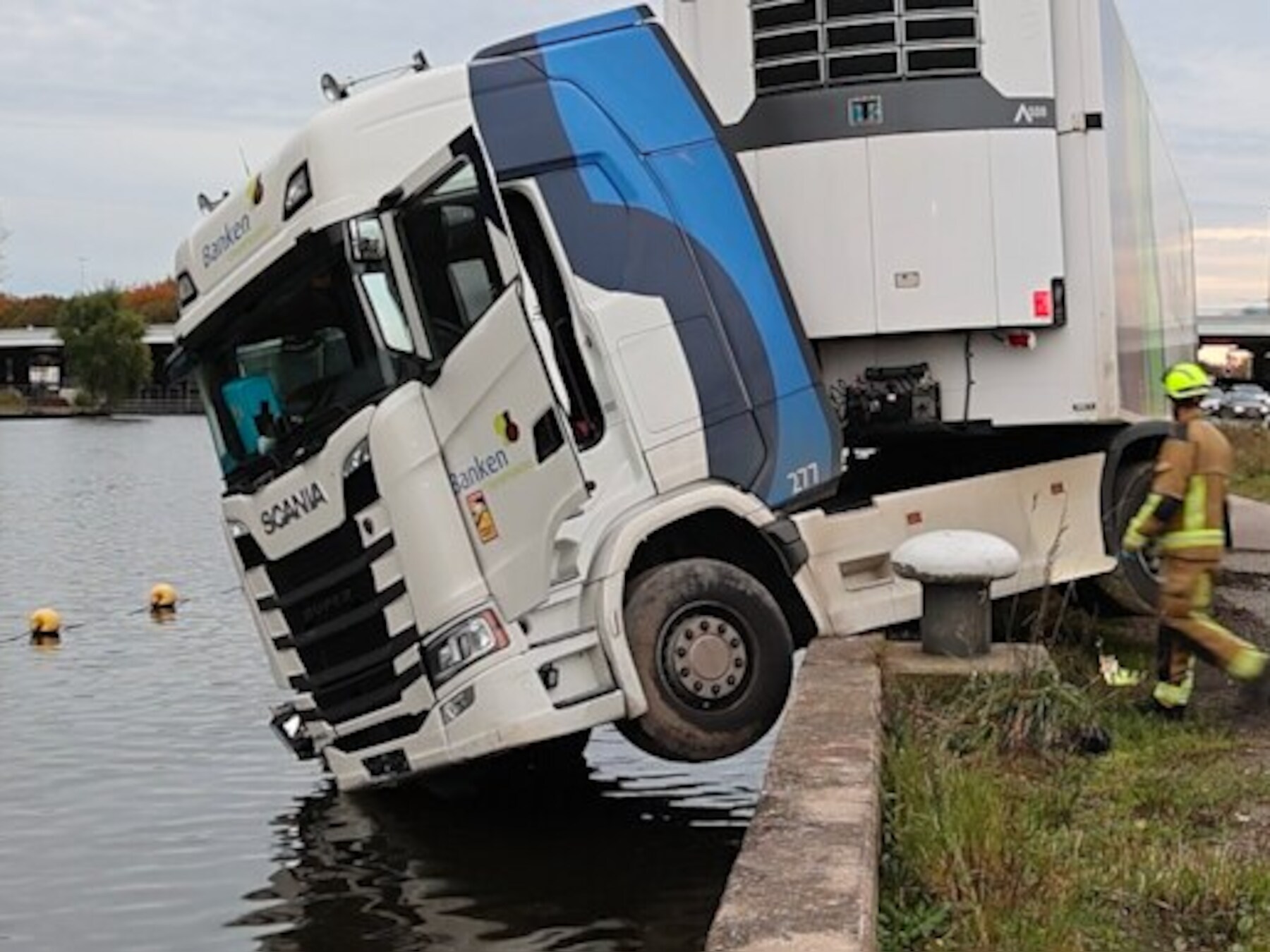 Vrachtwagencabine bungelt boven het water in Badhoevedorp
