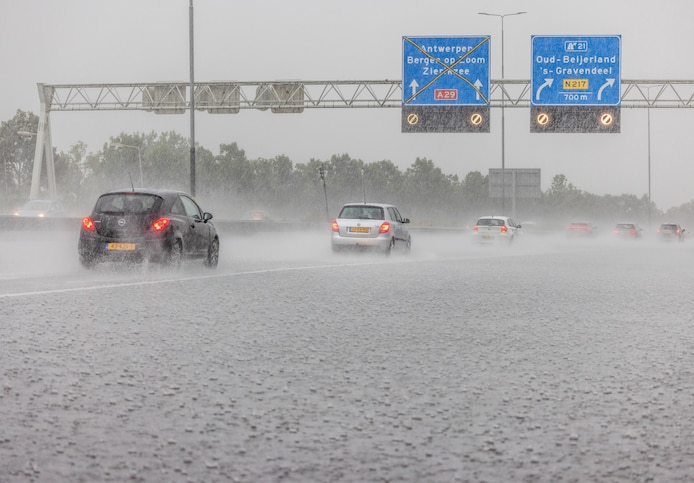 autos-rijden-langzaam-op-de-snelweg-door-hevige-regenval