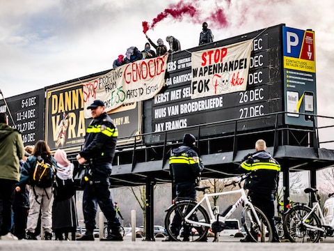 De demonstranten klommen op het aankondigingsbord en staken rookfakkels aan.