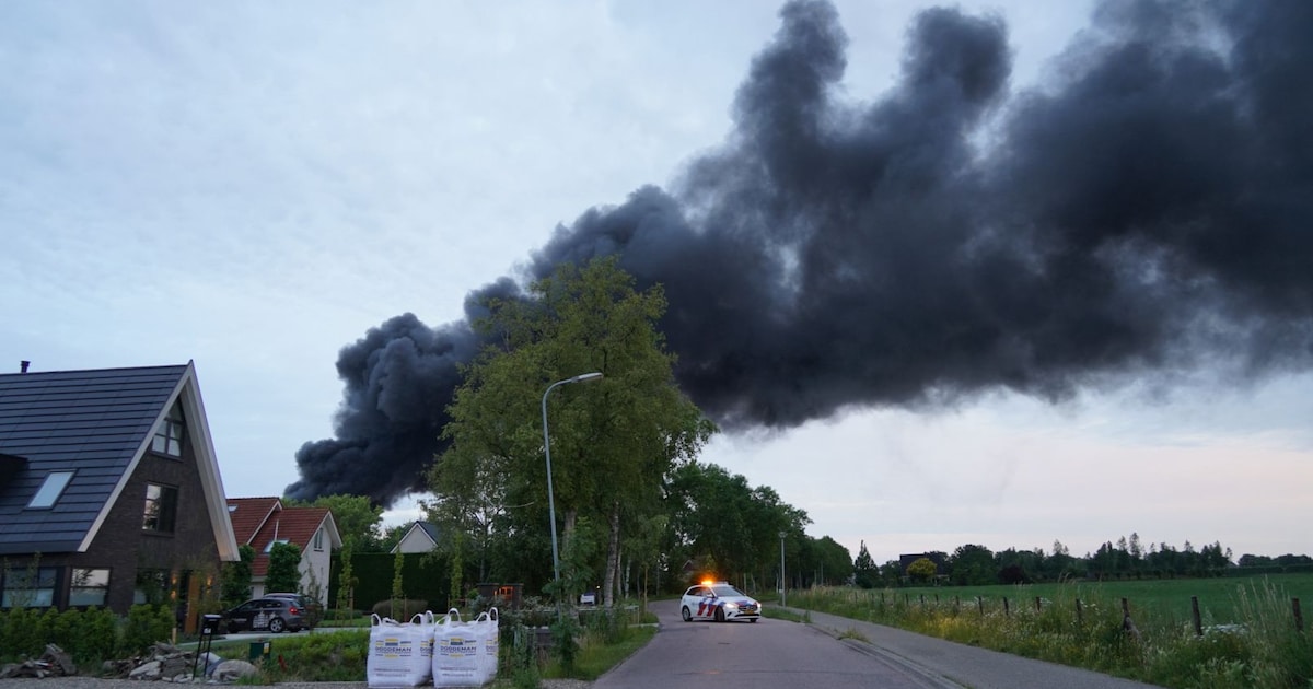 Zwarte rookwolken door grote brand bij bedrijfspand op Gildenweg in Blokker
