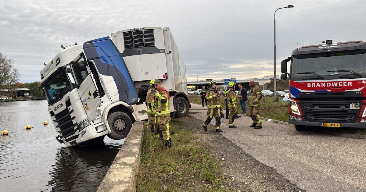 Vrachtwagenchauffeur bungelt boven het water in Badhoevedorp