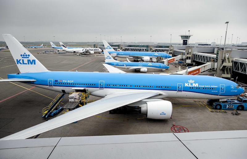 Grondpersoneel van KLM aan het werk op de luchthaven Schiphol. Vanwege de grote drukte vroeg Schiphol luchtvaartmaatschappijen in mei om het aantal reizigers te verminderen.
