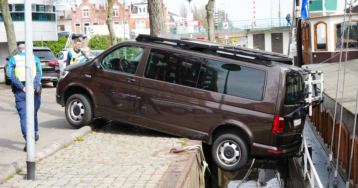 Camperbus rolt parkeervak uit aan de Oosterkade in Groningen en leunt tegen schip