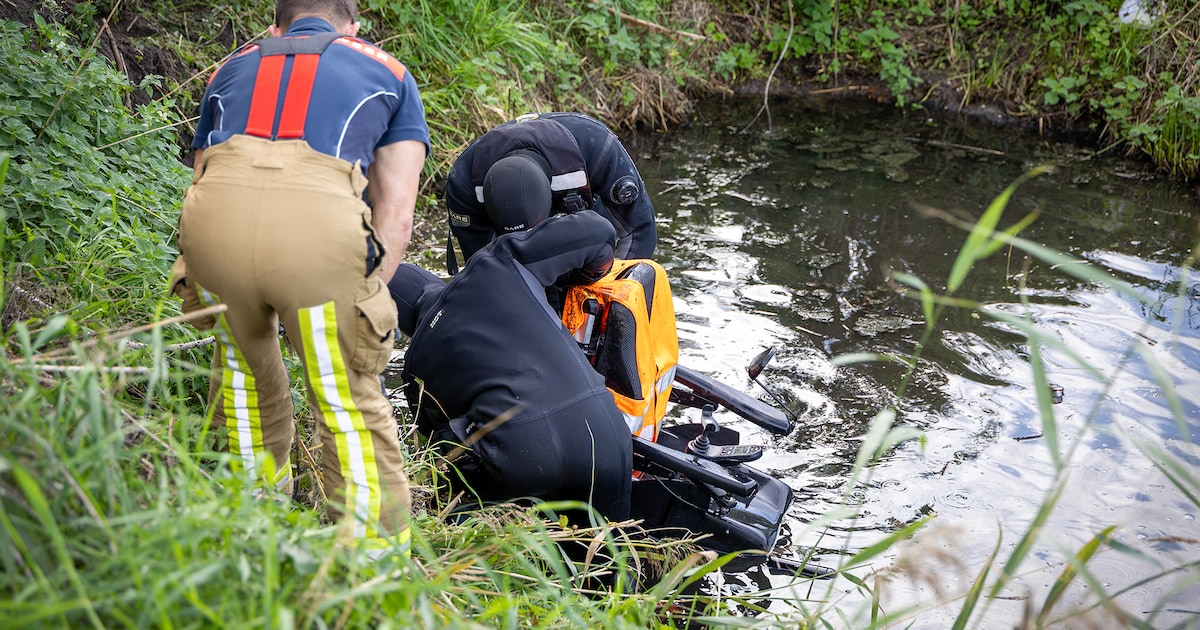 Persoon met scootmobiel te water op Veerpad in Haarlem