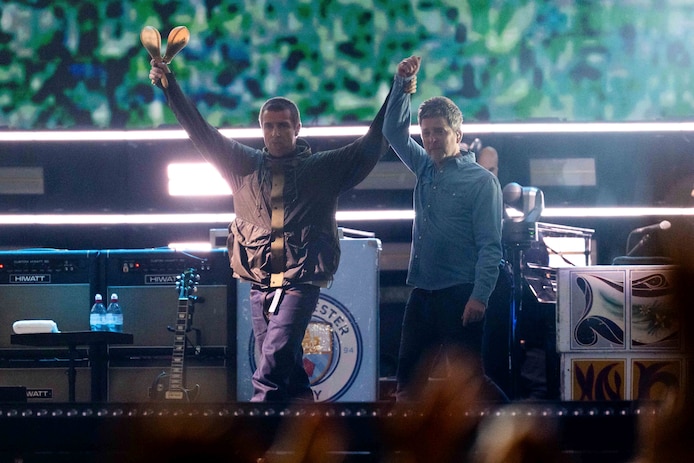 liam-gallagher-links-en-zijn-broer-noel-gallagher-hand-in-hand-op-het-podium-in-wales