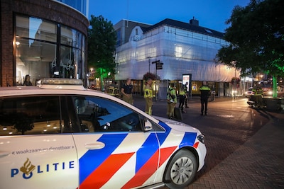 Man met vishengel klimt in bouwsteigers in centrum Apeldoorn