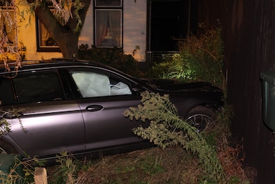 Automobilist knalt tegen lantaarnpaal en door hek heen in Rhenen