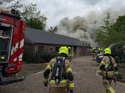 Brandweer nog geruime tijd bezig met brand in schuur, deel van gebouw dreigt in te storten