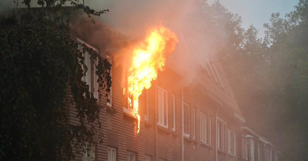 Vlammen slaan uit raam van woning in Enkhuizen, brand kan overslaan naar buren