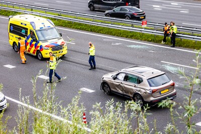 Auto op zijn kant op de A15 bij Rotterdam, brandweer bevrijdt slachtoffer