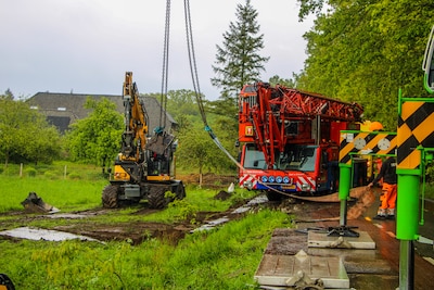 Kraanwagen zakt weg in nat geregende berm