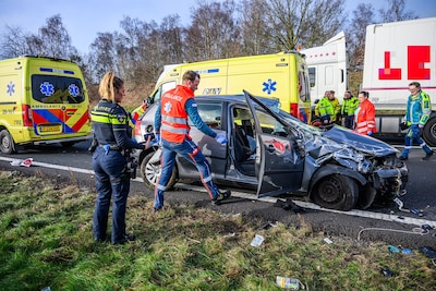 Auto slaat over de kop op A58 bij Breda: twee gewonden, flinke ravage