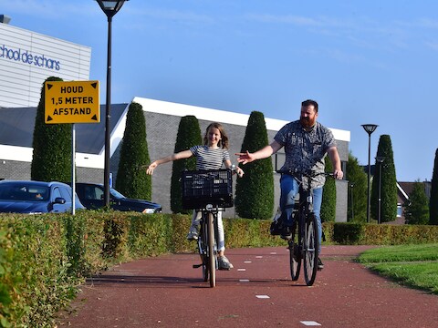 Vader Frans Stoffels oefent de fietsroute naar school met zijn dochter Jasmijn.