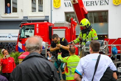 Papegaai zit vast in Apeldoorn: applaus van volle terrassen als brandweer hem vangt