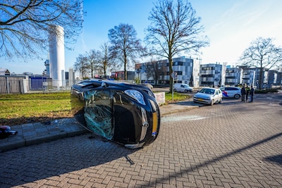 Auto op zijn kant na aanrijding op kruising in Eindhoven