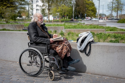 Meneer Leeuwenberg (82) zit in een rolstoel bij station Tilburg en vraagt of mensen hem een stukje k