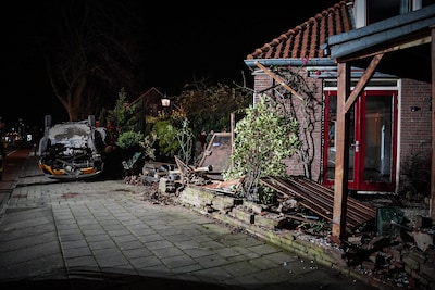 Auto botst tegen tuinmuur en slaat over de kop: ravage groot
