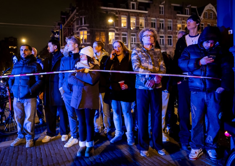 Buurtbewoners en passanten kijken tijdens de nieuwjaarsnacht naar de brandende Vondelkerk