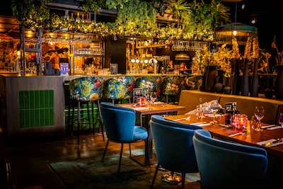 Gastheer schittert aan tafel met vis, vlammen en garde