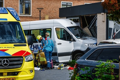 Taxibus rijdt gebouw in Enschede binnen, persoon komt onder voertuig terecht