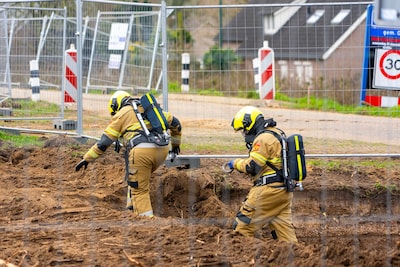 Brandweer dicht gaslek met tape bij werkzaamheden aan dijk bij Lithoijen