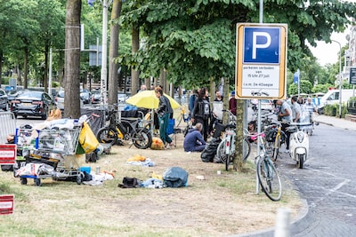 Tientallen daklozen zitten met tassen vol blikjes in gras voor opvang in Nijmegen: Vierdaagse leidt 
