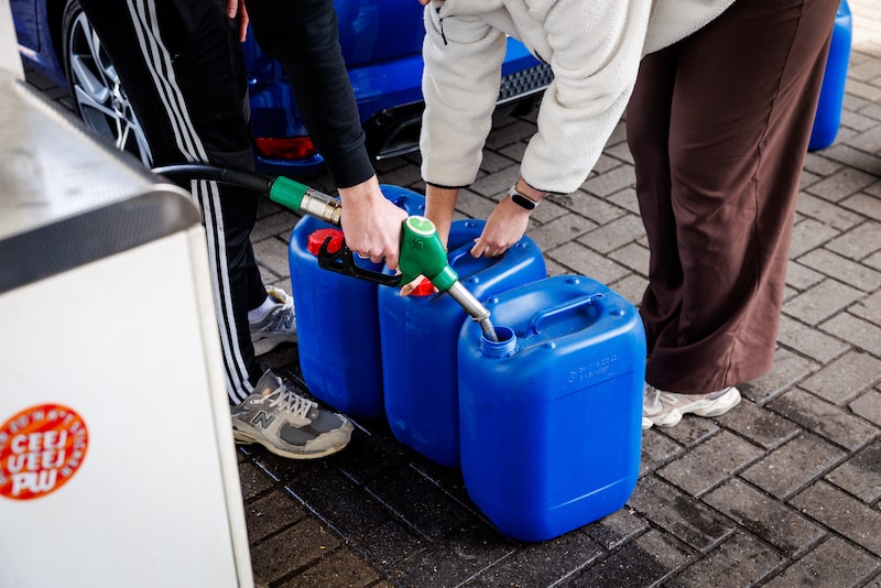Tanktoeristen vullen hun jerrycans, vlak over de grens in Meerle.