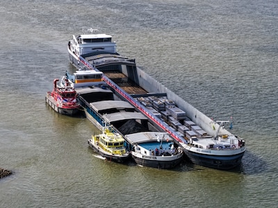 Vrachtschip met kolen lekgeslagen op de Waal en dreigt te zinken, brandweer en Rijkswaterstaat helpe