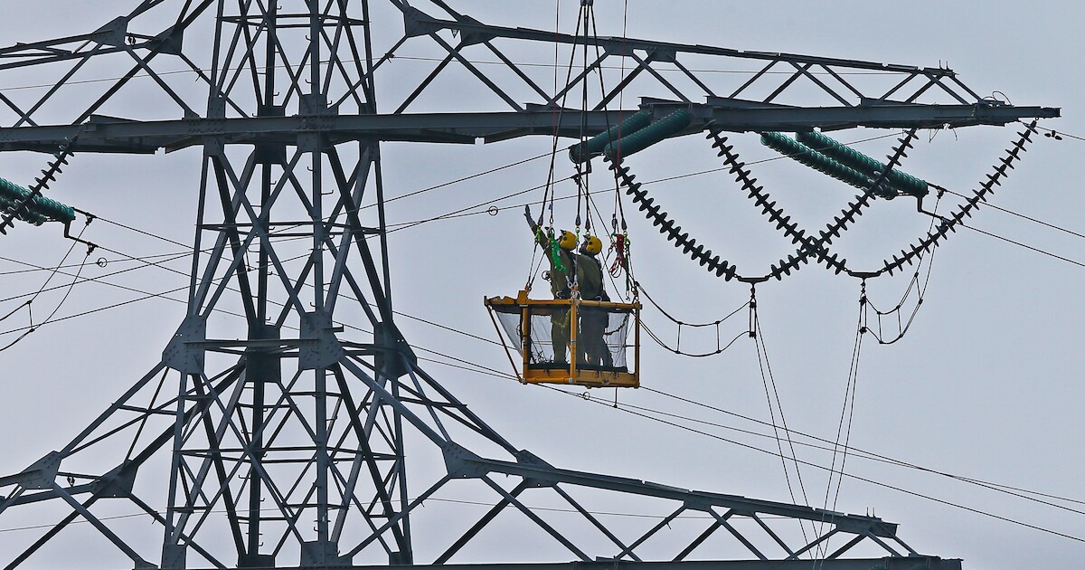 Spectaculair! Monteurs hangen vanuit mandje onder helikopter vlaggetjes aan stroomdraden