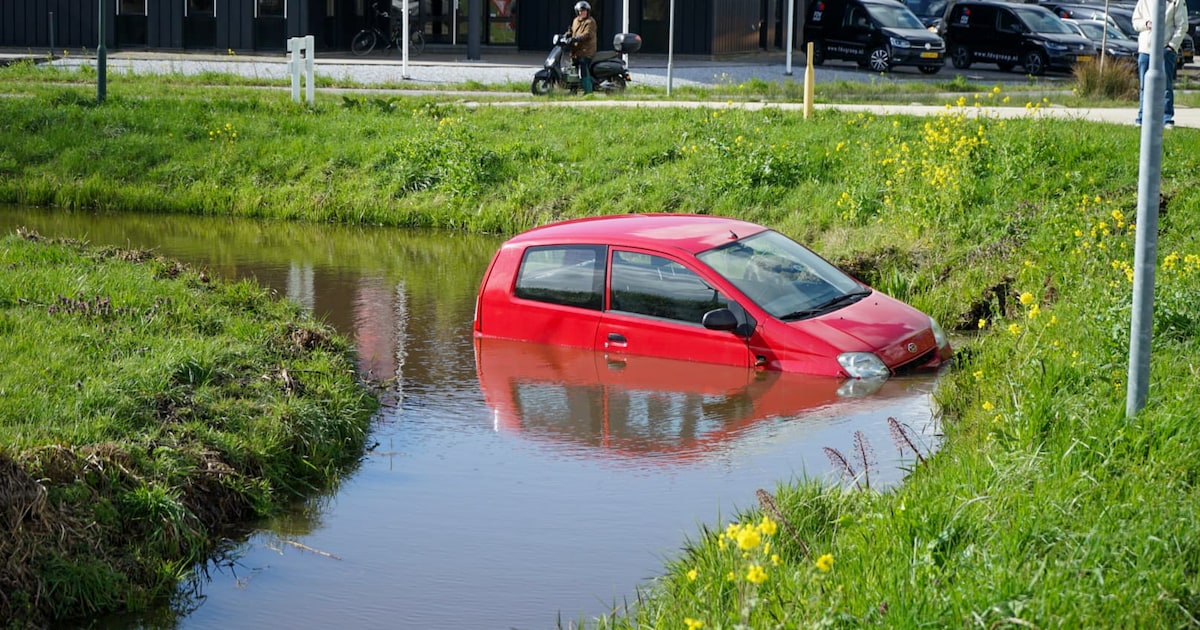 Auto belandt in het water langs de C.M. van Houwelingweg in Giessenburg