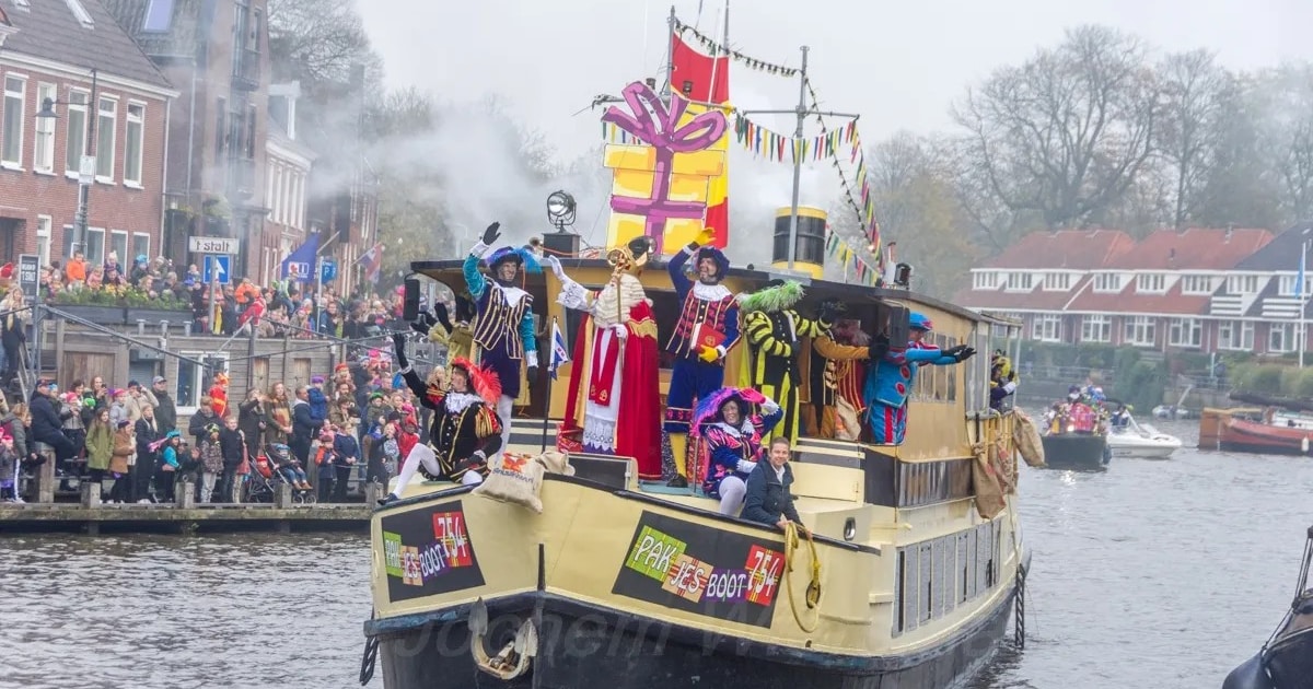 Pakjesboot komt in de avond aan tijdens de Sinterklaasavondintocht in Dokkum
