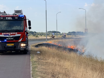 Droog gras vliegt in brand langs de Havendijk in Tiel