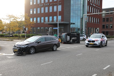 Auto op zijn kant na botsing in Ede