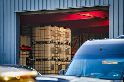 Inval bij Eindhovens transportbedrijf: zwaarbewapende agenten houden de wacht, grote vaten en kratte