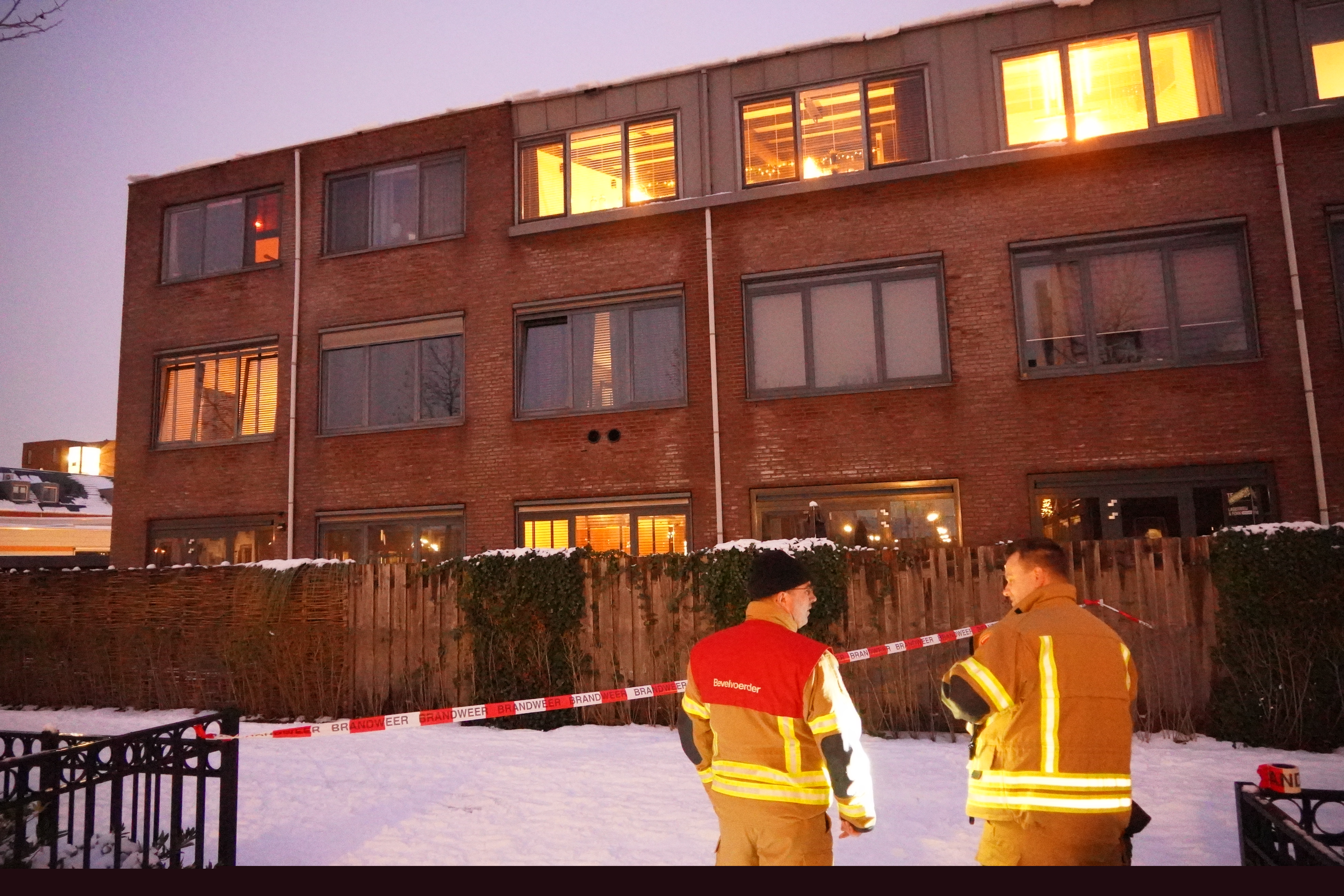 Veel sneeuw op dak van appartementencomplex in Bergschenhoek, brandweer plaatst afzetlint