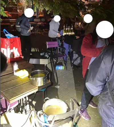 Grote groep kookt en dineert op terras van restaurant dat van niks weet
