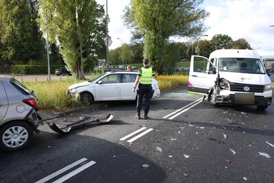 Busje botst tegen afslaande auto’s in Waalwijk, weg bezaaid met brokstukken