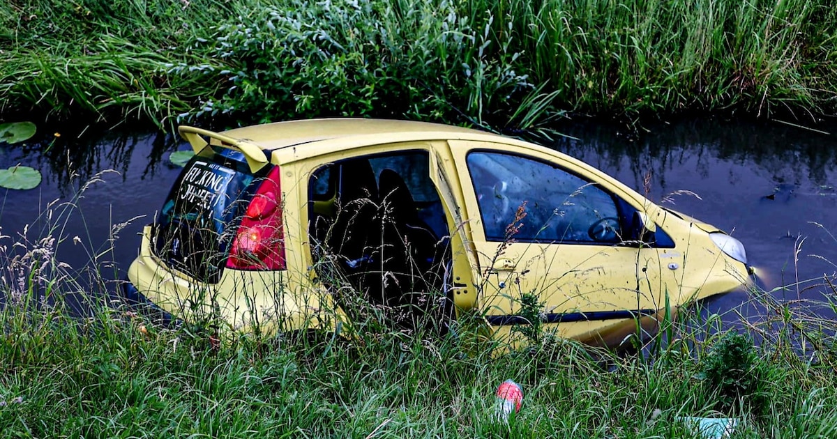 Auto te water in Lopik, omstanders helpen bestuurster op het droge