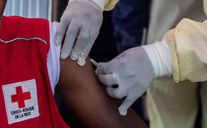 A Congolese health care provider administers an MPOX vaccination to a Red Cross worker.
