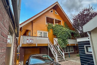 Dit houten huis heeft van buiten de sfeer van een sauna, een kantoor aan huis én een verwarmd zwemba